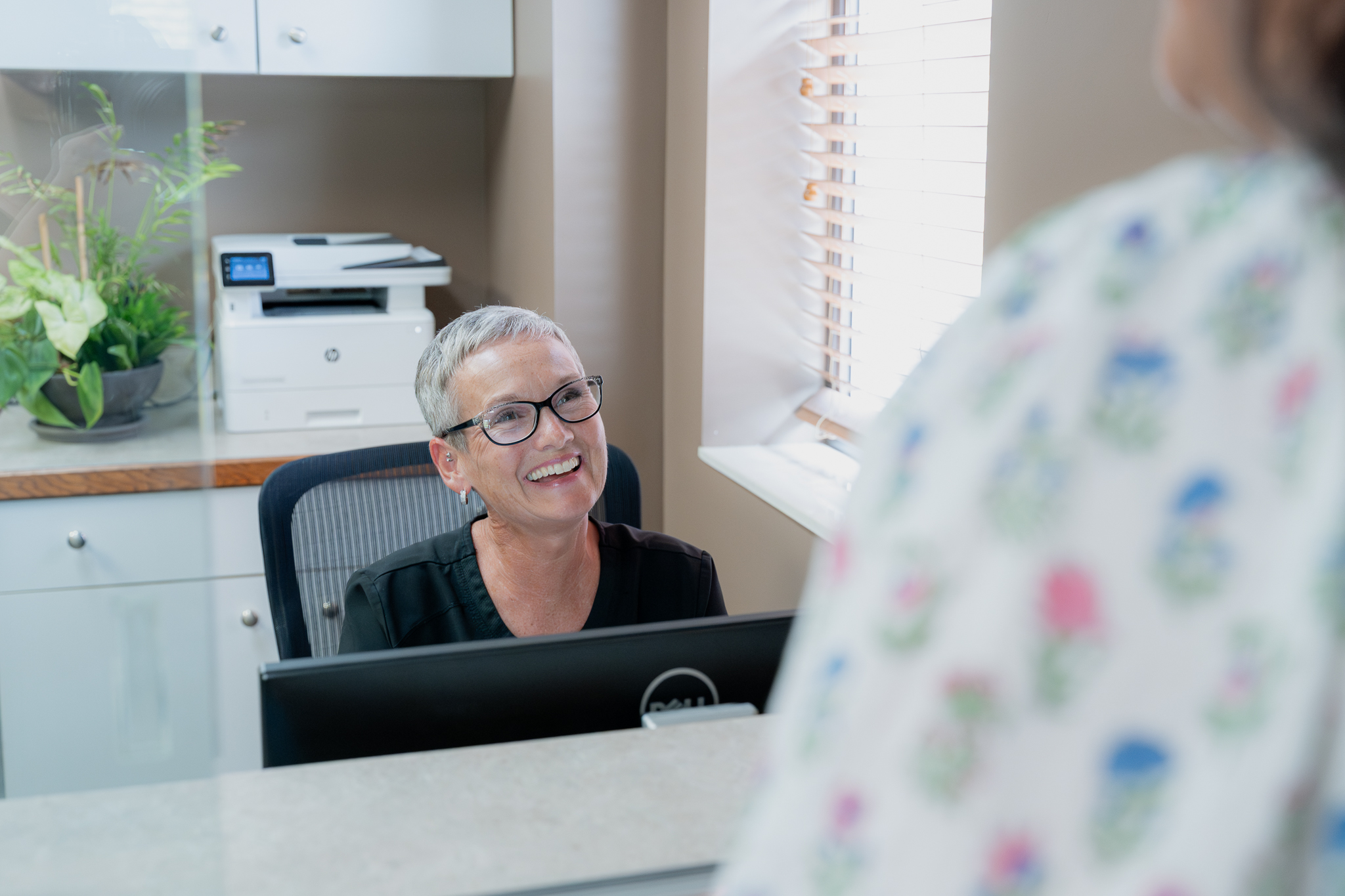 Front desk team member greeting a patient at reception