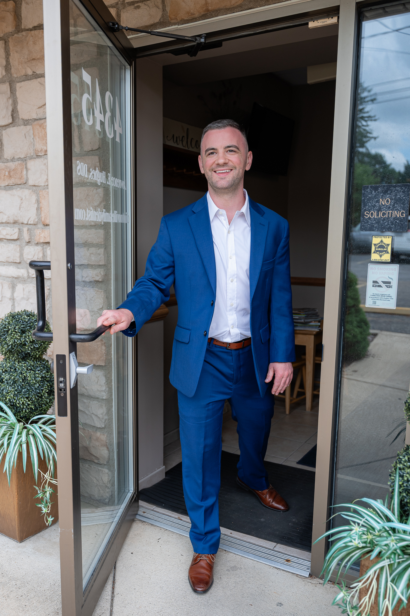 Dr. Thomas Rouse, DDS, holding open the front door of the Clintonville office